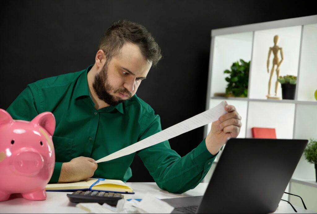 Pessoa analisando extrato bancário e percebendo que perdeu o controle financeiro.