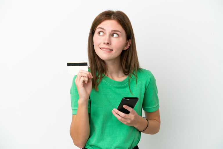 Pessoa analisando score de crédito no celular e refletindo sobre aprovação de crédito.