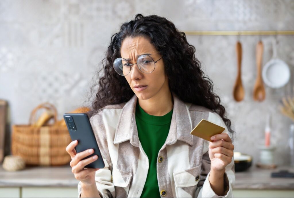 Pessoa analisando fatura e refletindo sobre os juros do cartão