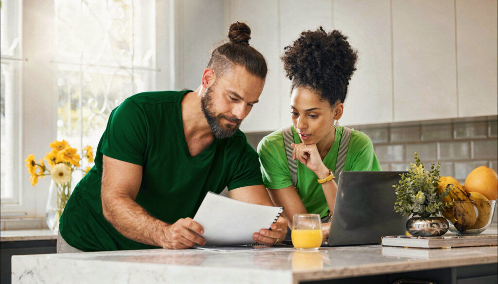 Casal conversando sobre organização financeira para casais com planilhas e calculadora”