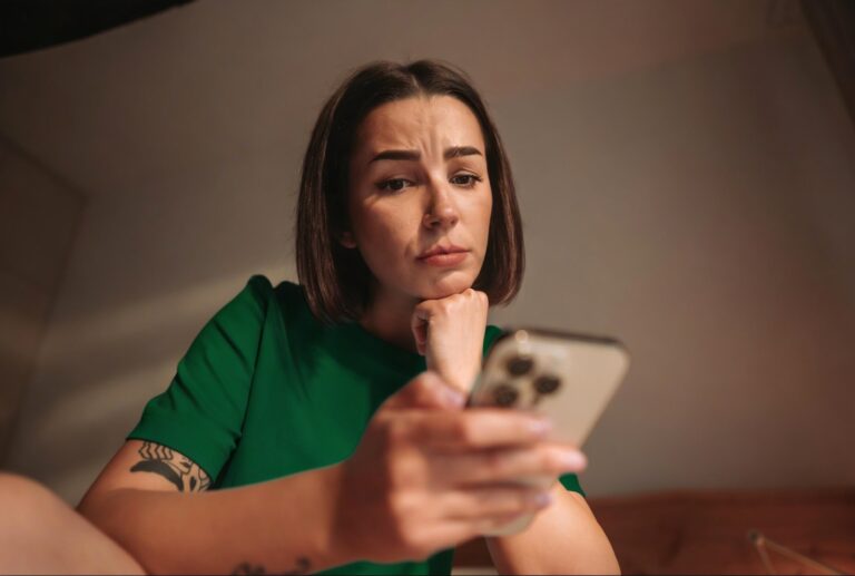 Pessoa preocupada ao perceber que o score caiu ao consultar aplicativo financeiro